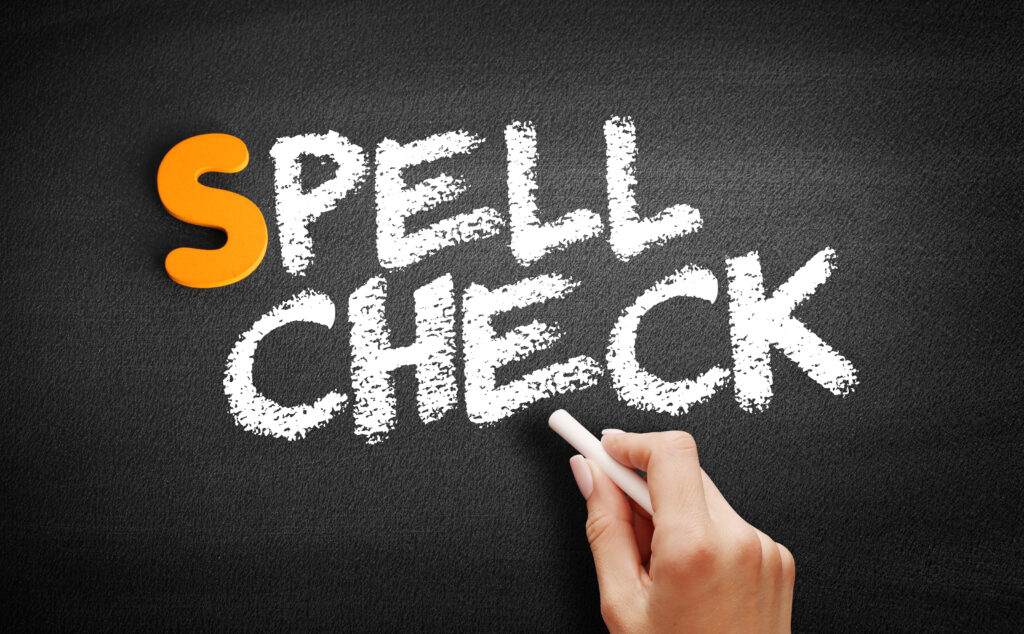 Main &eacute;crivant "Spell check" &agrave; la craie